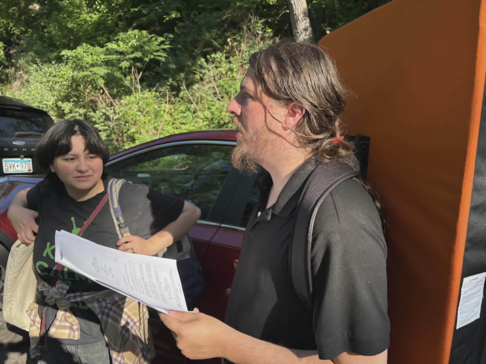 Director reviewing script pages with a cast member on location before a shoot